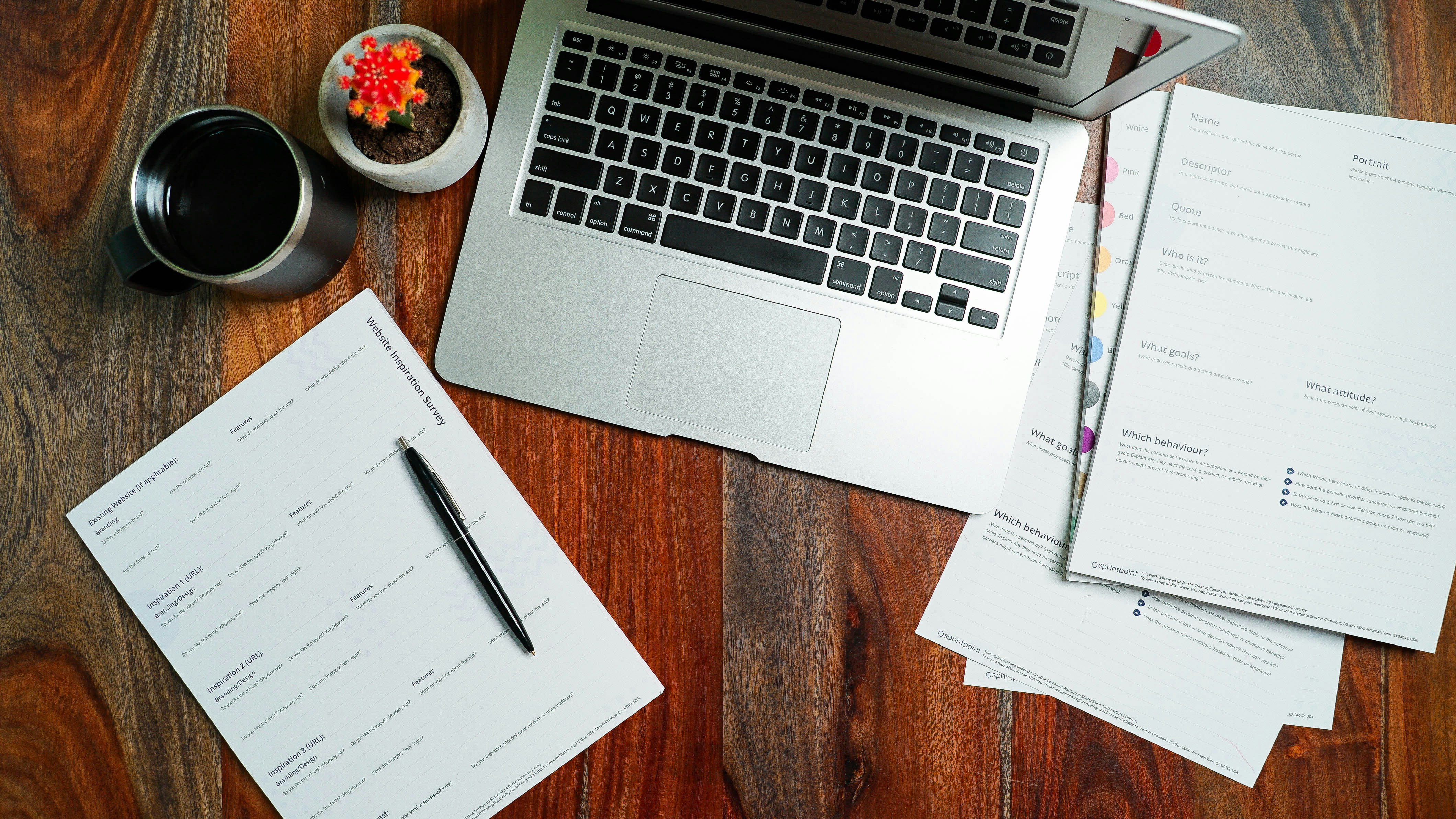 Research notes beside a laptop on a desk